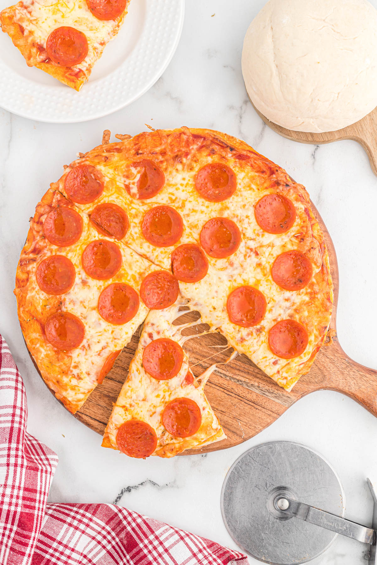 cooked pizza on cutting board.