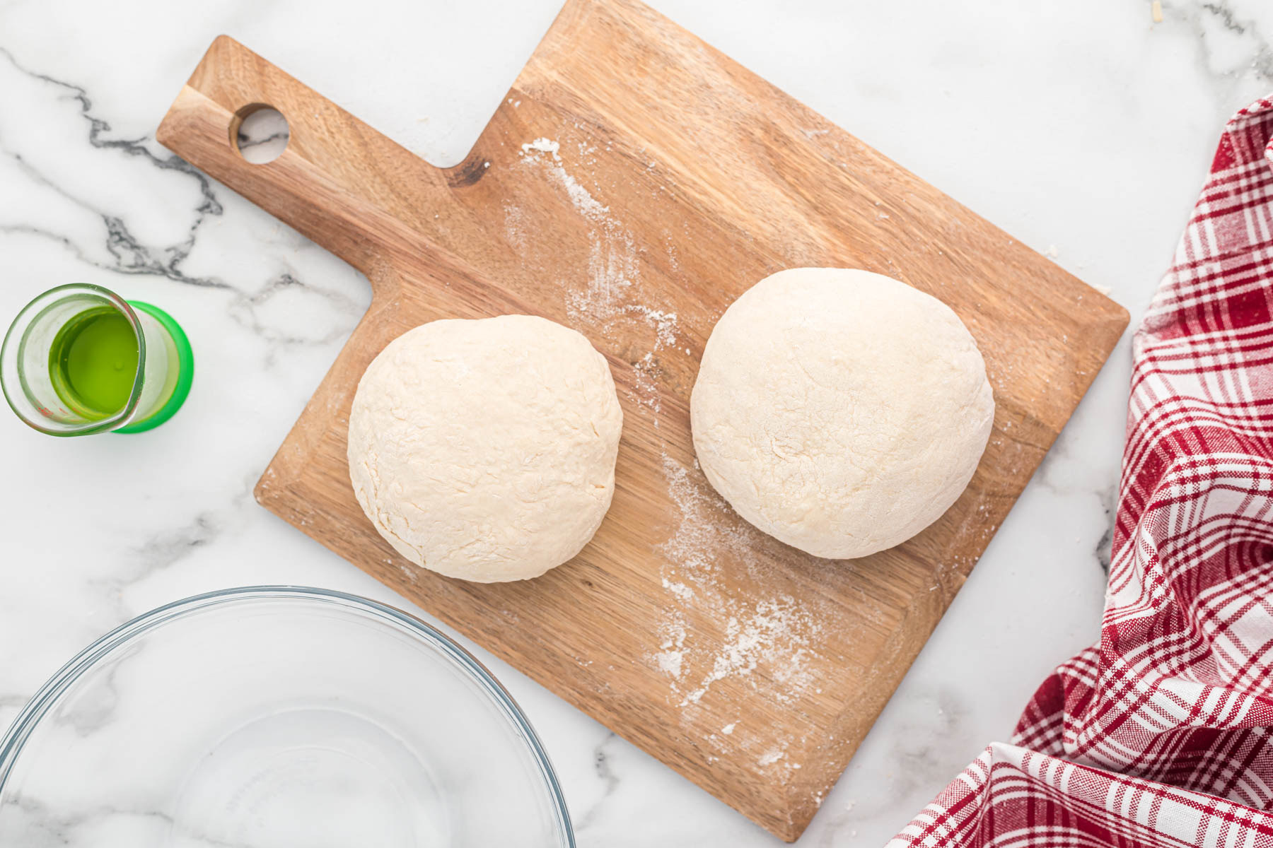 dough divided in half in mixing bowl.