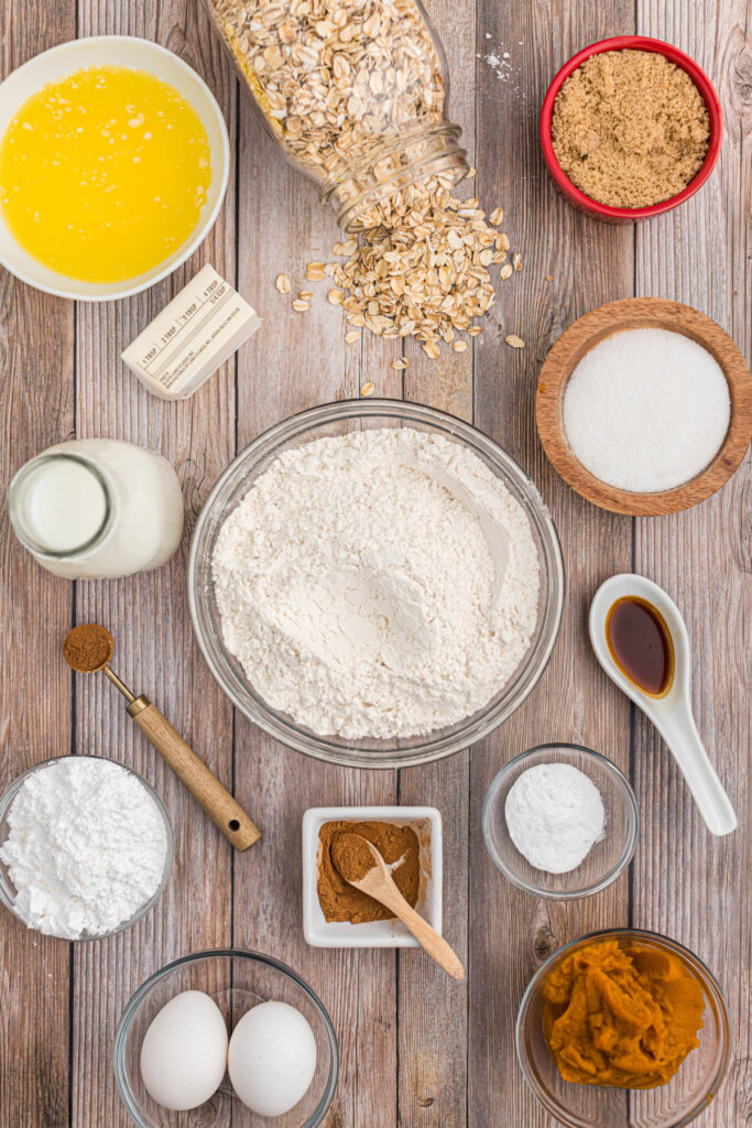 ingredients for Pumpkin Oatmeal Muffins on brown background.