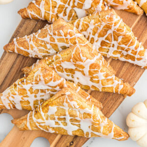 air fryer pumpkin turnovers on wooden board.