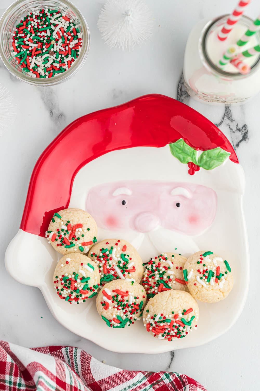 Vanilla Christmas Cookies on Santa plate with glass of milk.