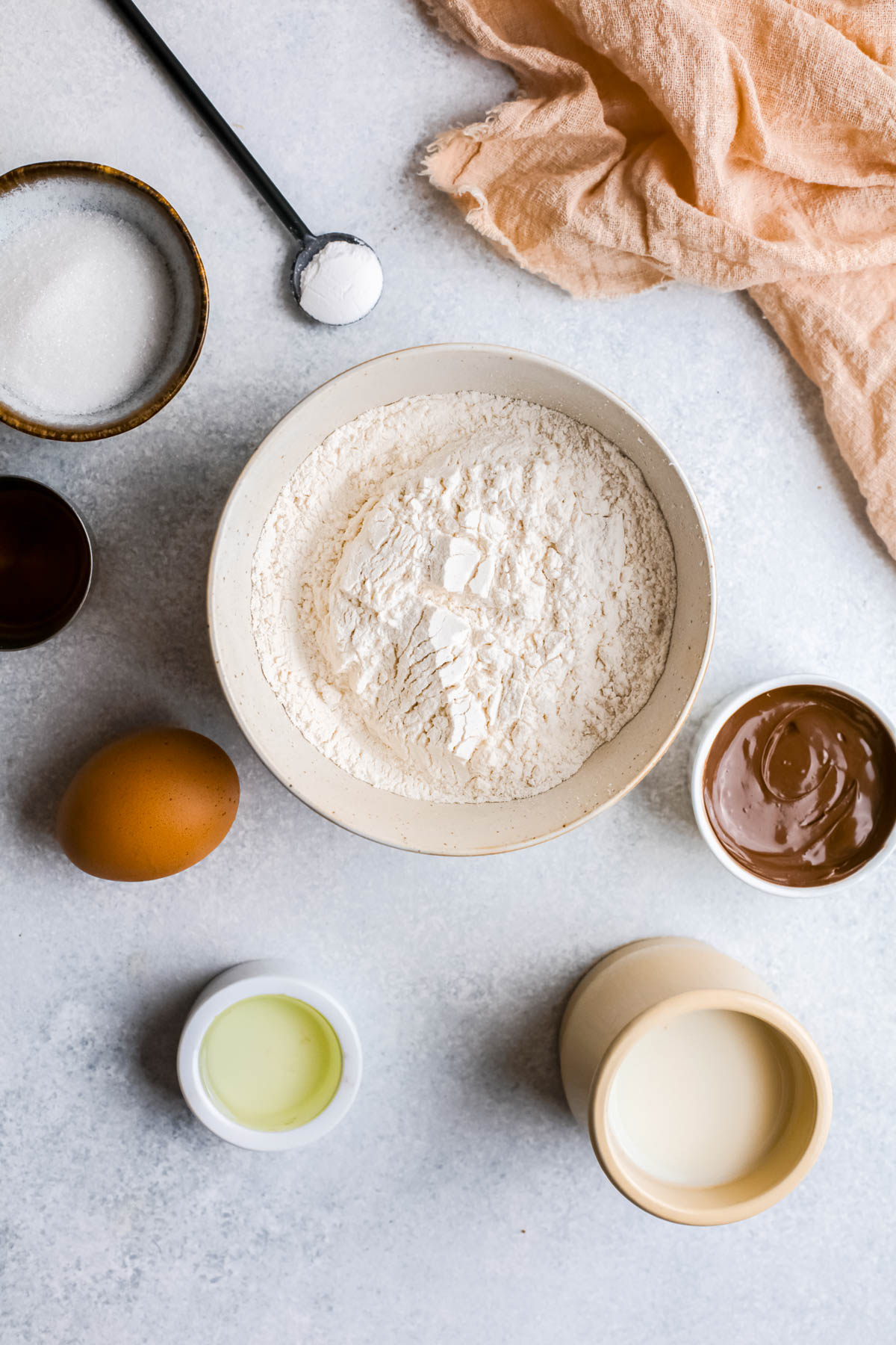 Ingredients for Nutella Donut Holes in bowls on white back ground.