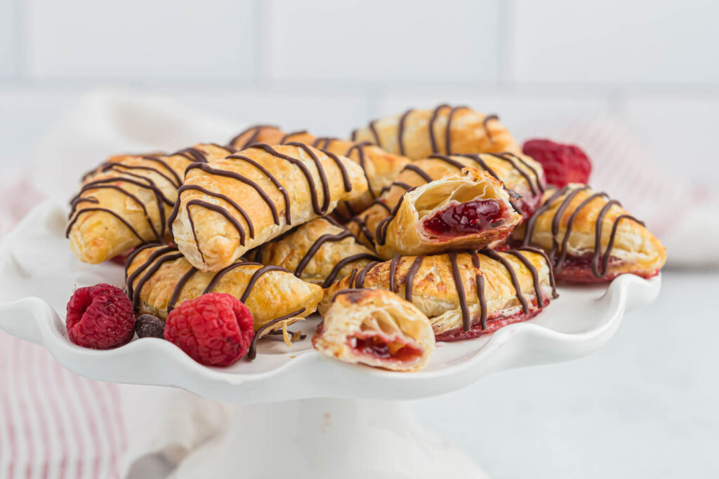 raspberry hand pies stacked on platter.