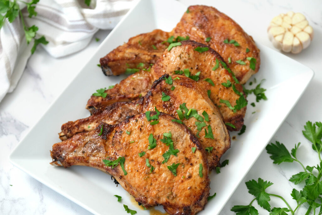 pork chops covered with fresh parsley.