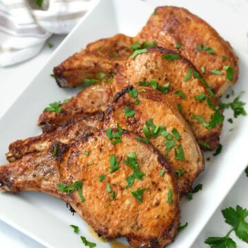 pork chops covered with fresh parsley.