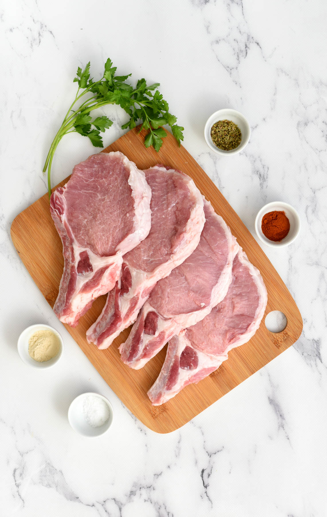 ingredients for pork chops on butcher block.