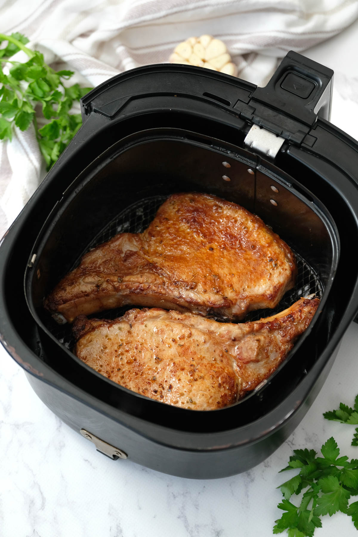 Air fryer pork chops with a crispy golden brown exterior and tender, juicy meat inside.