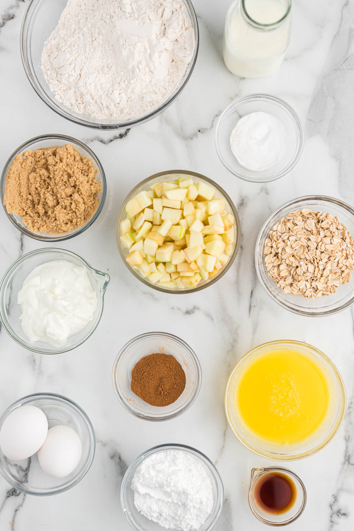 ingredients for apple cinnamon oatmeal muffins in glass bowls.