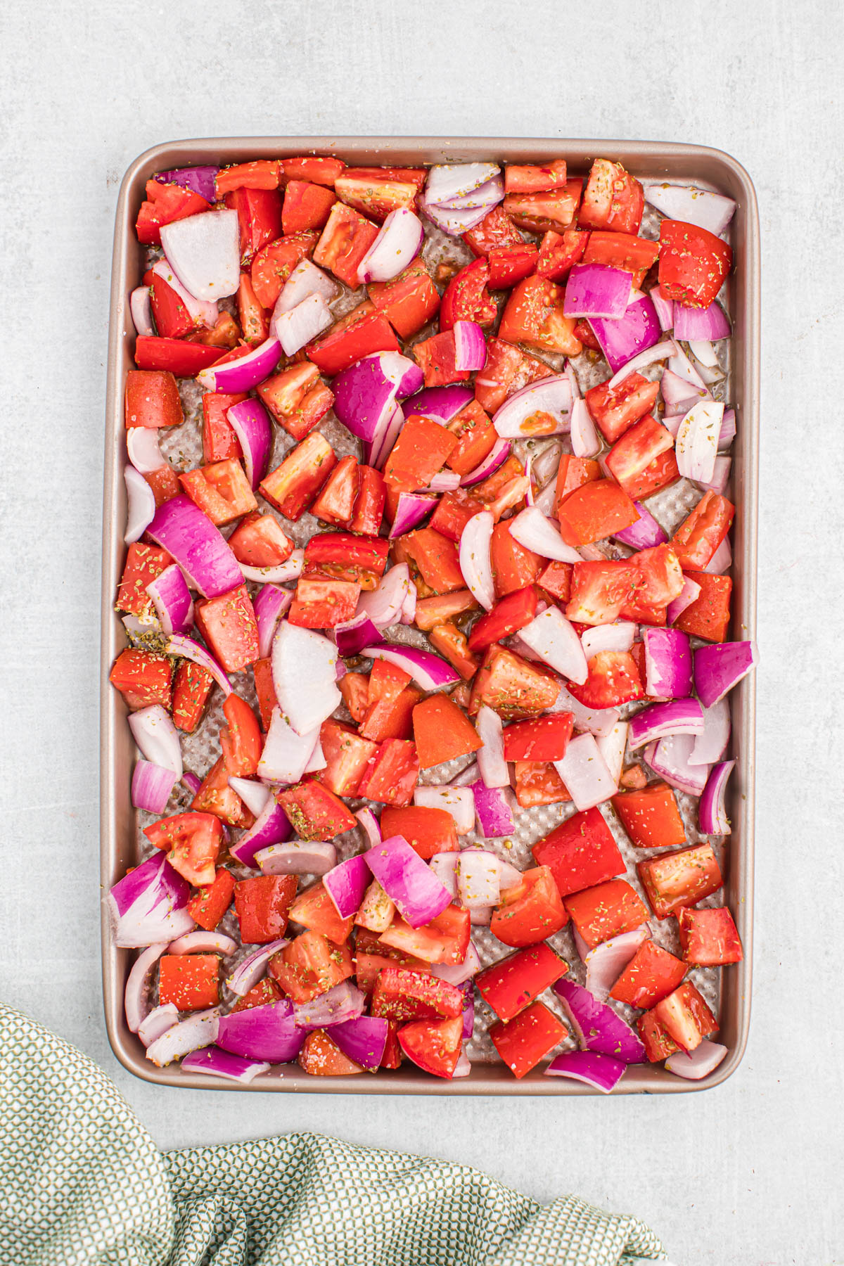 uncooked tomatoes and onions on sheet pan