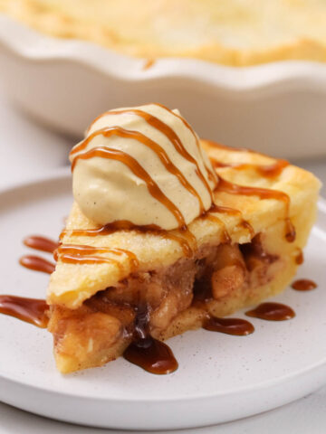 simple apple pie on white plate with caramel drizzle