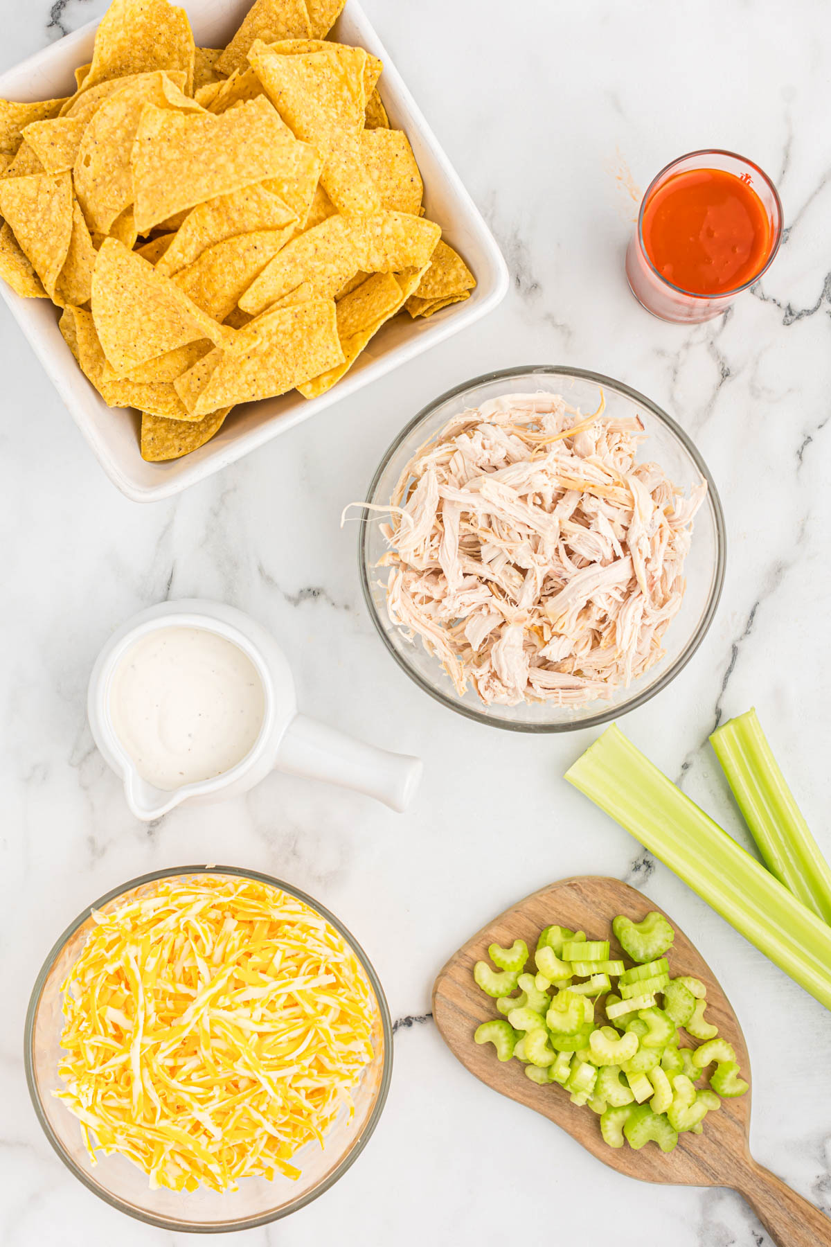 ingredients for buffalo chicken skillet nachos in bowls