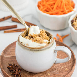 carrot cake mug cake with spoon in white mug