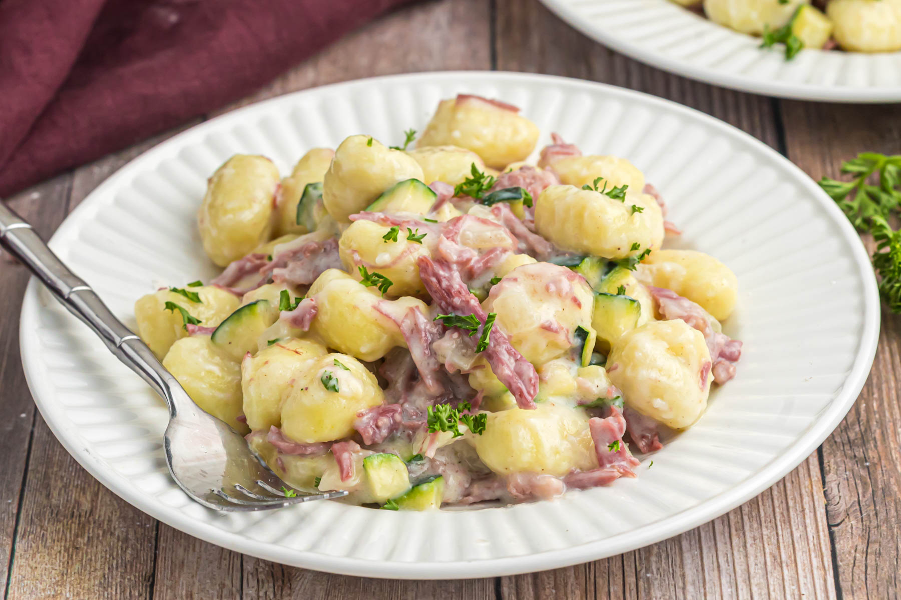 Creamy Gnocchi with Corned Beef on white plate with fork